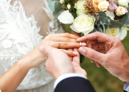 a groom placing a ring on a brides finger